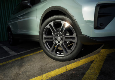 Seat Arona Alufelgen Detail mit Mehrspeichen-Leichtmetallrädern, schwarzer Radlaufverkleidung und erhöhter Bodenfreiheit.