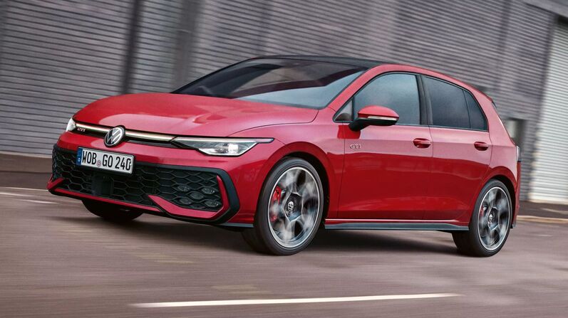 VW Golf GTI in rot fährt sportlich die Straße entlang.
