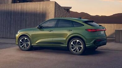 Audi Q5 Sportback in Distriktgrün Metallic parkt vor moderner Architektur, mit sportlicher Coupé-Silhouette, durchgehender LED-Heckleiste und 20-Zoll-Leichtmetallrädern.