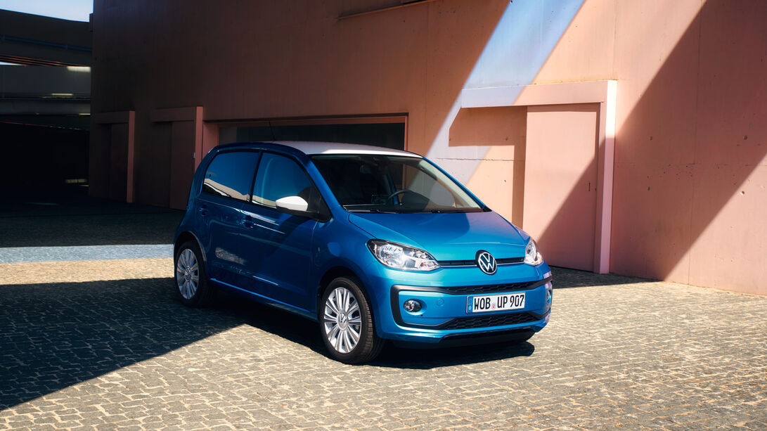 Ein blauer VW up! steht vor moderner Architektur. Der kompakte Personenkraftwagen zeigt sich hier als wendiges Stadtauto mit klarer Front und typischer Marke-Optik.