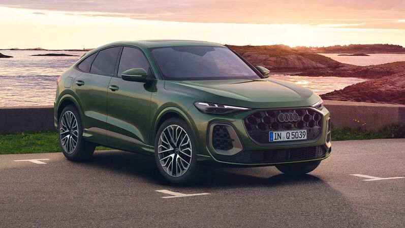 Audi Q5 Sportback Edition One in Distriktgrün Metallic mit Magnesiumgrau-Akzenten fährt an der Küste, 21-Zoll-Felgen und Wabengrill.