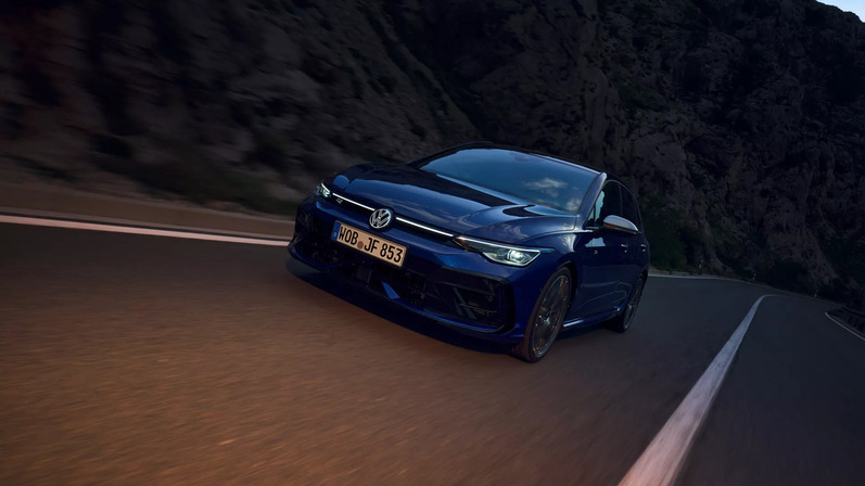 VW Golf R in blau fährt dynamisch die Straße entlang.
