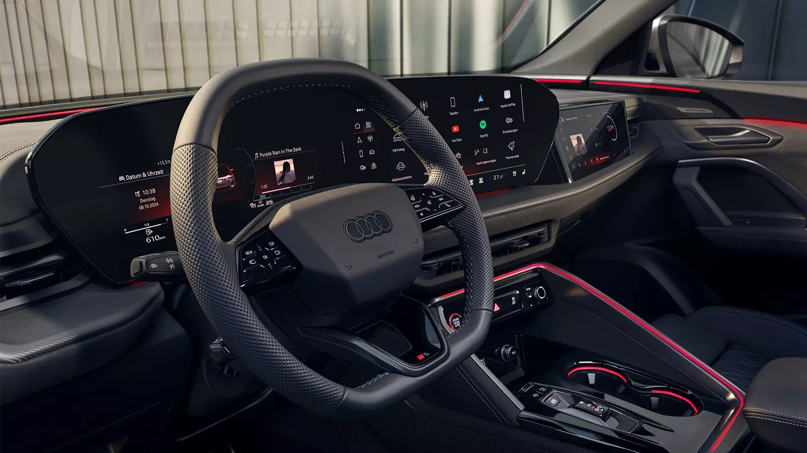 Innenraum vom SQ5 der 3 Generation. Fokus auf das sportliche 3 Speichen Lenkrad mit S-Logo, MMI-Displays, rote Akzentbeleuchtung.