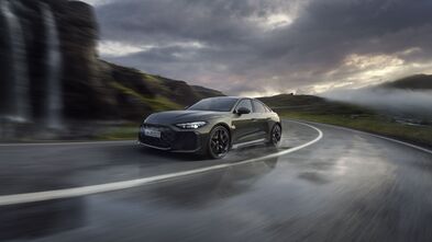 Limousine Audi RS5 in bedfordgrün auf nasser Straße, mit sportlichem Look und starkem Power-Auftritt – das Sportfahrwerk sorgt trotz Gewicht für dynamische Kontrolle in der Kurve.