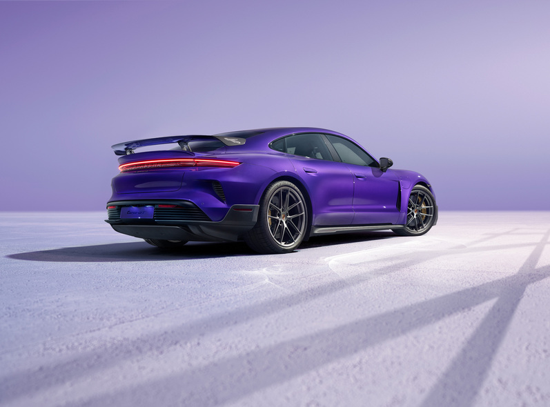 Heckansicht des Taycan Turbo GT vor einem lila Hintergrund