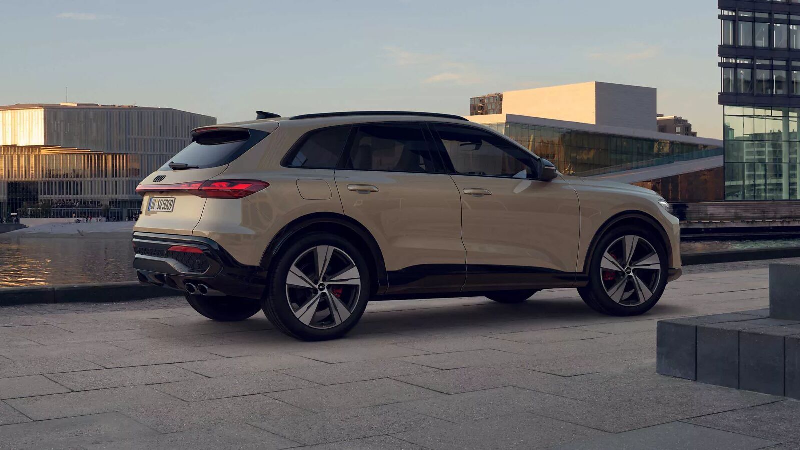 SQ5 Suv Edition one in Beigegrau mit schwarzen Akzenten steht elegant am Wasser.