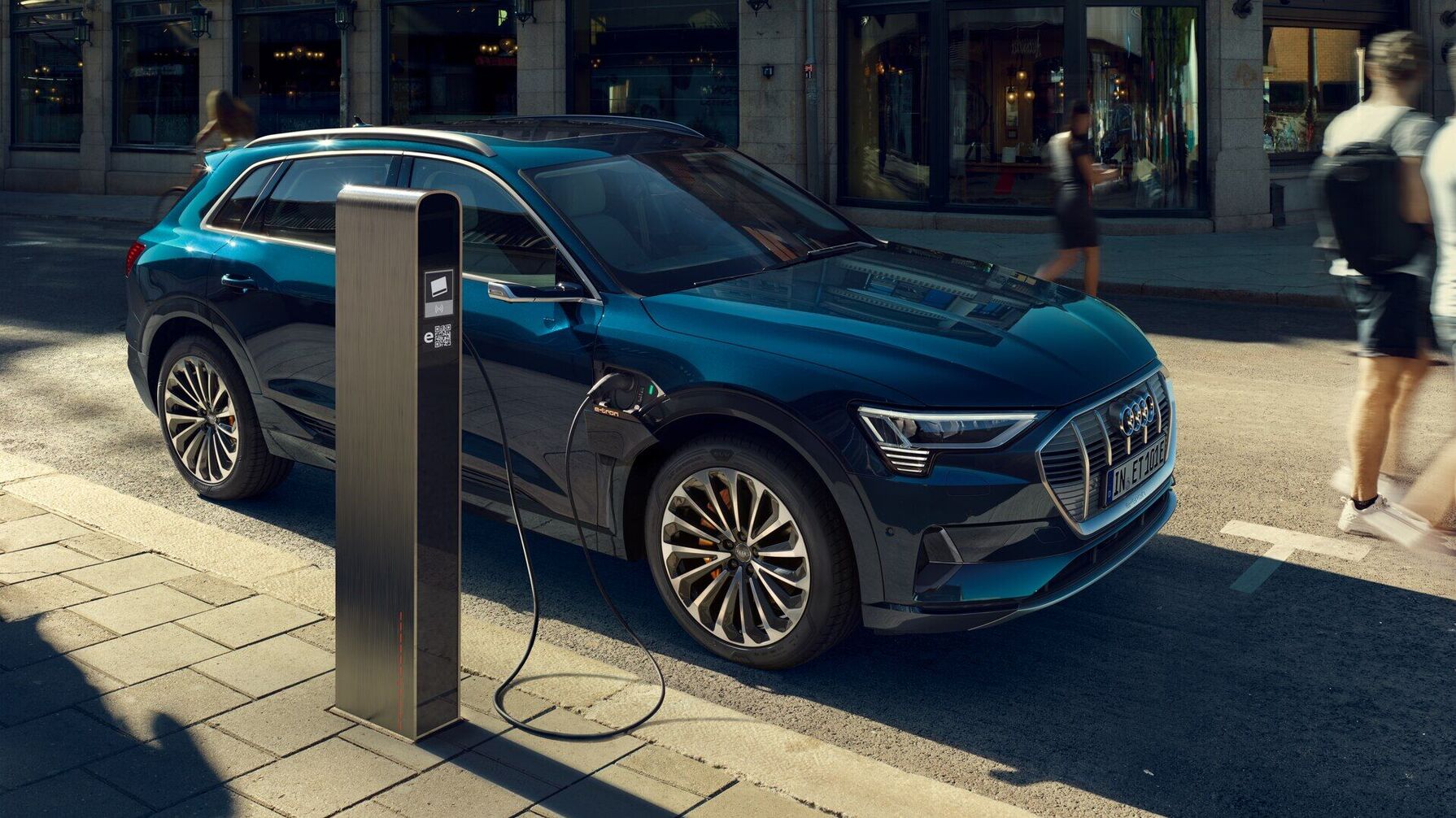Der Audi e-tron in blauer Lackierung zeigt sich mit markantem Singleframe-Design, scharf konturierten LED-Scheinwerfern und aerodynamisch geformten Felgen.