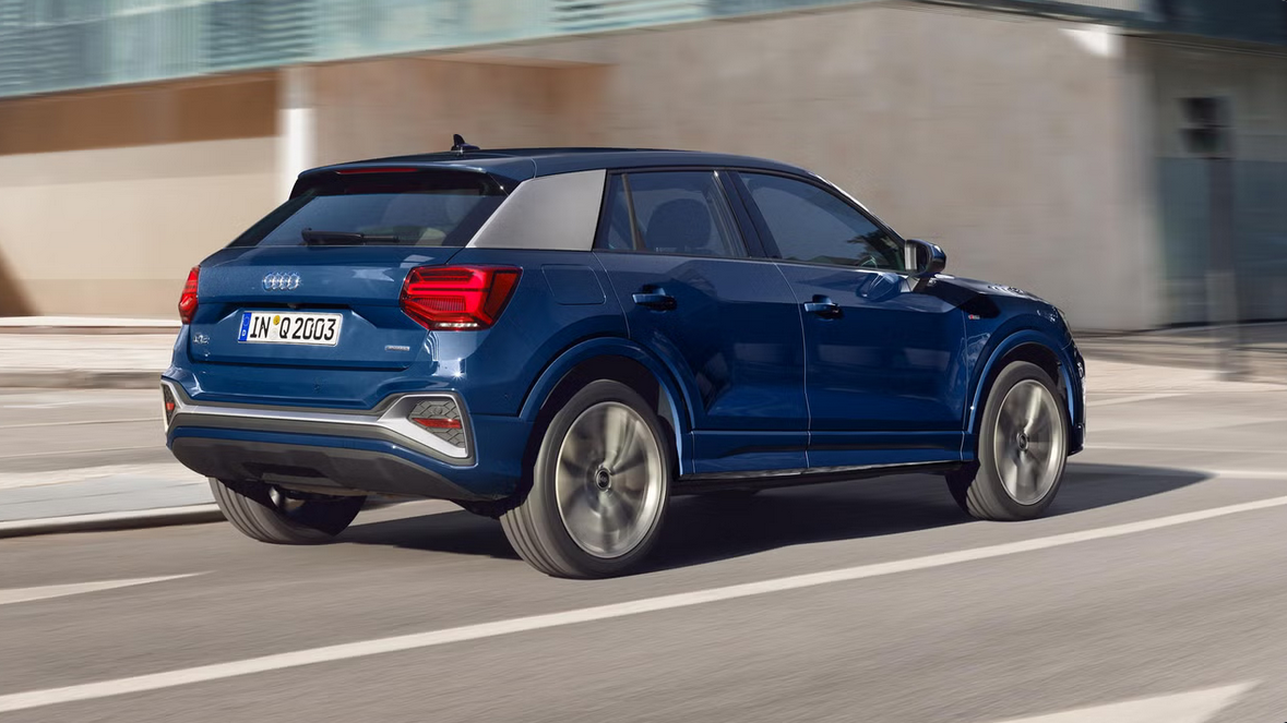 Der Audi Q2 in blauer Lackierung wirkt kompakt und kraftvoll mit markanten LED-Rückleuchten, kontrastierendem Dachdesign und robust geformten Karosserielinien.