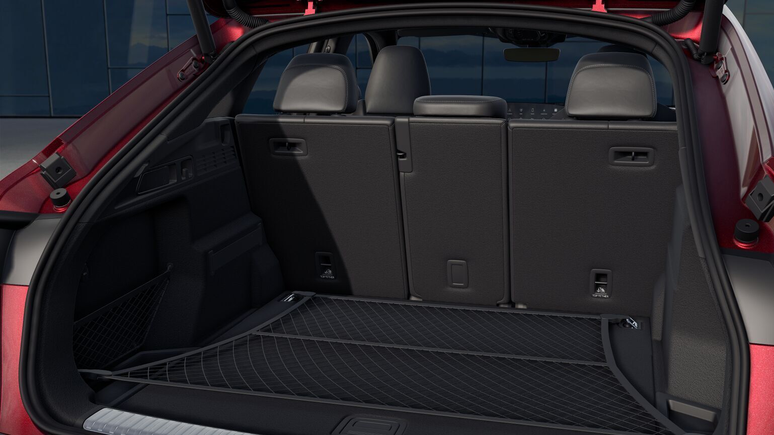 Offener Kofferraum des Audi SQ5 in Grenadinerot Metallic mit variabler Rücksitzbank, Ablage und ebenem Ladeboden.