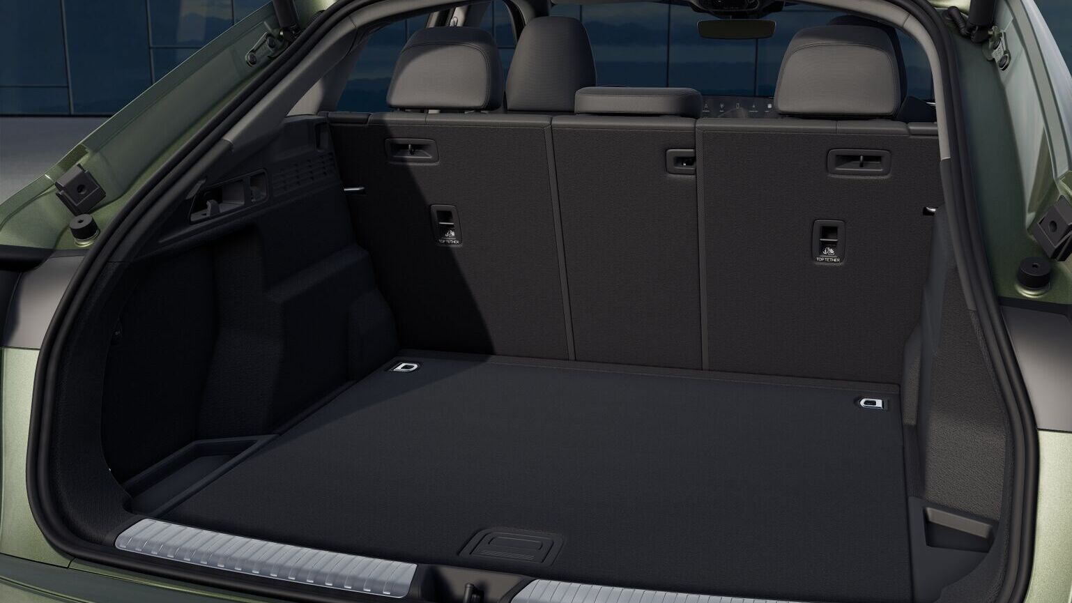 Offener Kofferraum des Audi Q5 Sportback in Distriktgrün Metallic mit variabler Rücksitzbank, Ablage und ebenem Ladeboden.