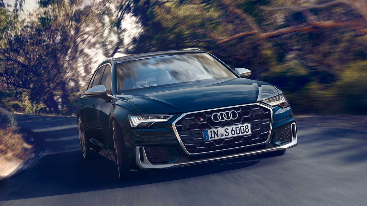 Der Audi S6 Avant zeigt sich in dynamischer Fahrt mit sportlicher Frontpartie, markantem Singleframe-Grill, scharf gezeichneten LED-Scheinwerfern: