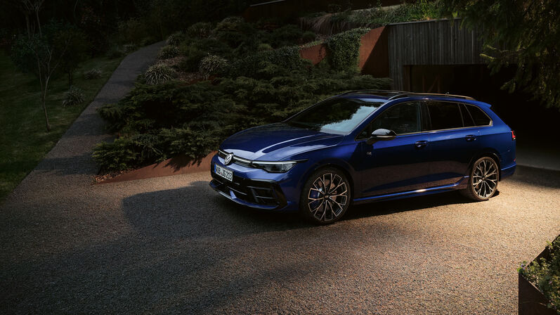 VW Golf Variant R in Blau, das Fahrzeug steht vor ein schönen Natur Haus. 