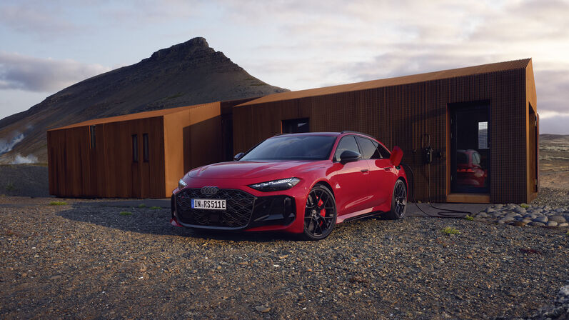 Audi RS5 Avant parkt vor einem modernen haus in wilder Berglandschaft.