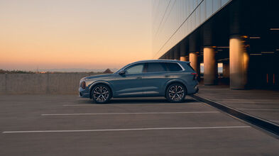 Der neue Audi Q7 SUV auf einem Parkplatz vor modernem Gebäude