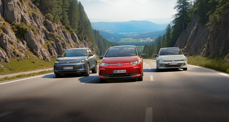 Volkswagen Energy Sondermodelle auf Bergstraße mit VW ID. Modellen und modernen SUVs in sommerlicher Landschaft.