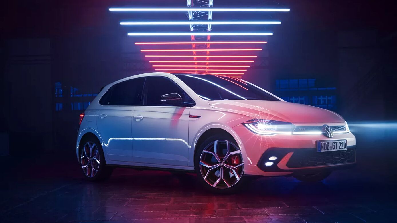 Der weiße VW Polo GTI steht unter markanter Neonbeleuchtung. Die sportliche Front und das präzise Setup zeigen Performance pur – auch mit optionaler Automatik.