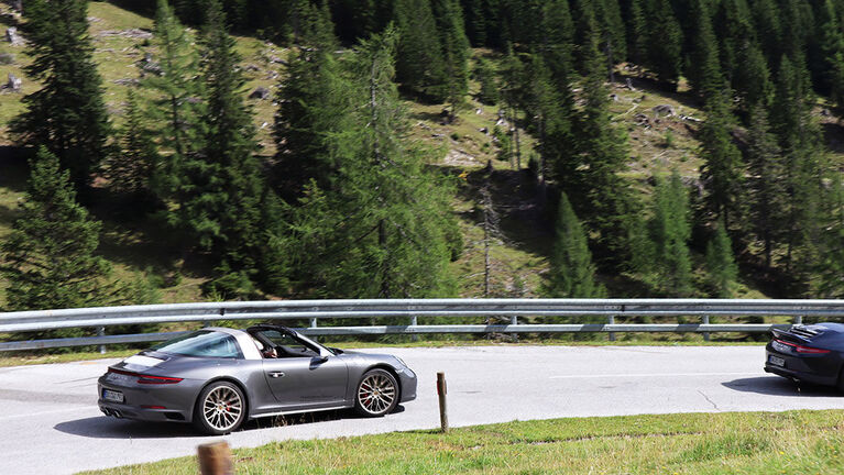 Zwei Porsche fahren eine kurvige Straße in Osttirol entlang