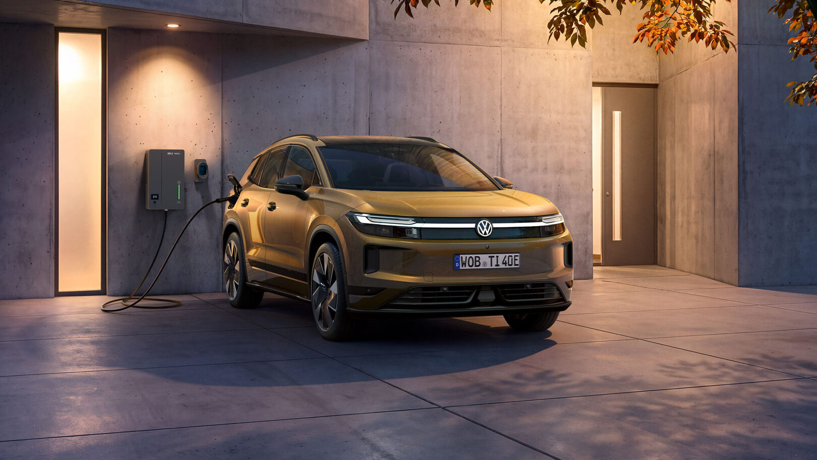 Der neue VW ID. Tiguan in olive-bronze an einer Ladestation an einem modernen Haus