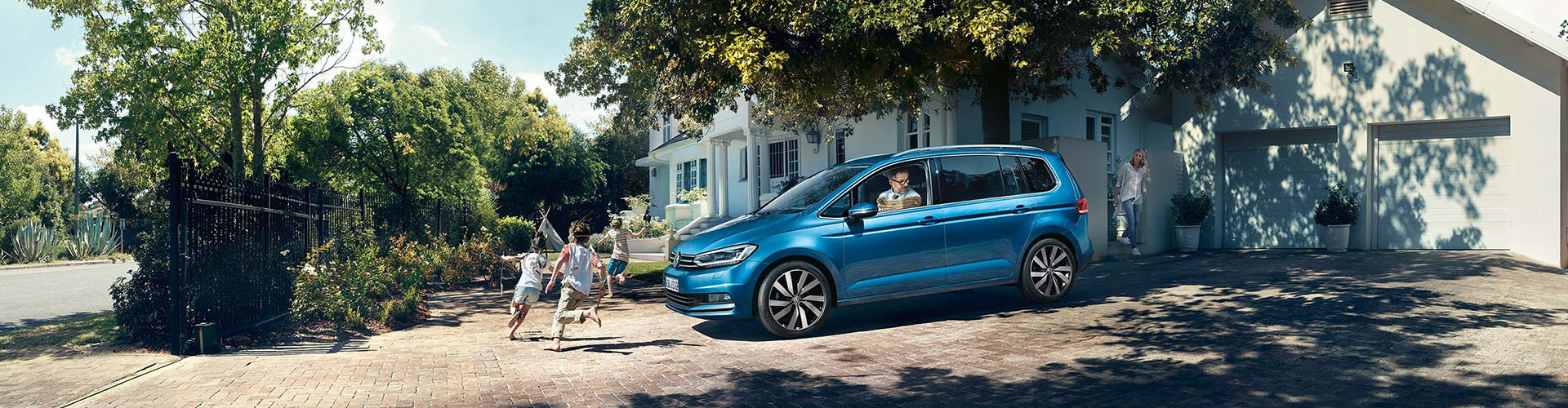 Volkswagen Touran un blau vor Familienhaus