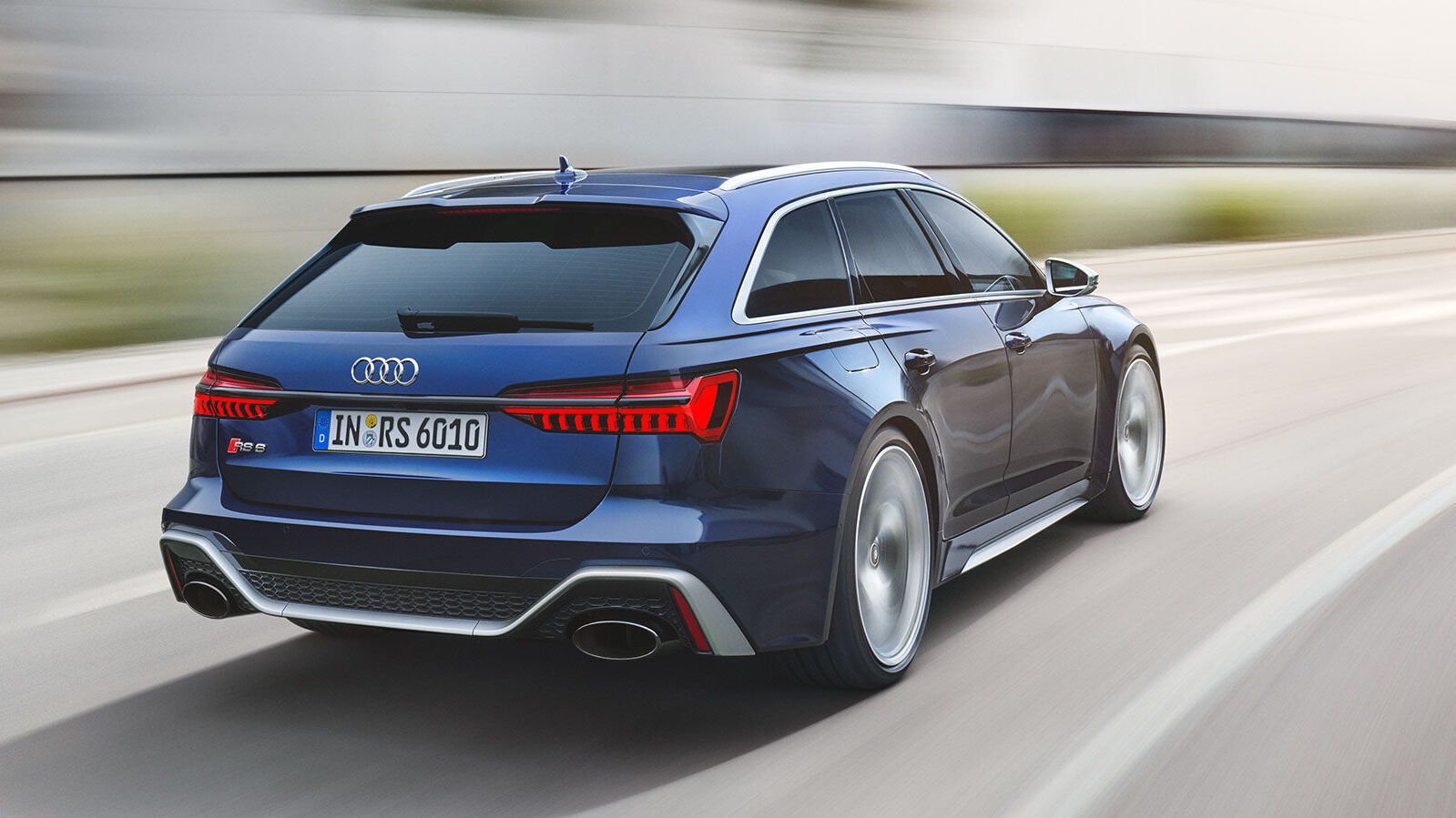 Der Audi RS6 von hinten, mit kräftigem Diffusor, ovalen Endrohren und auffälligen LED-Rückleuchten, in voller Bewegung.