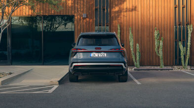 Audi Q7 SUV in der Heckansicht vor einem orangenen Gebäude