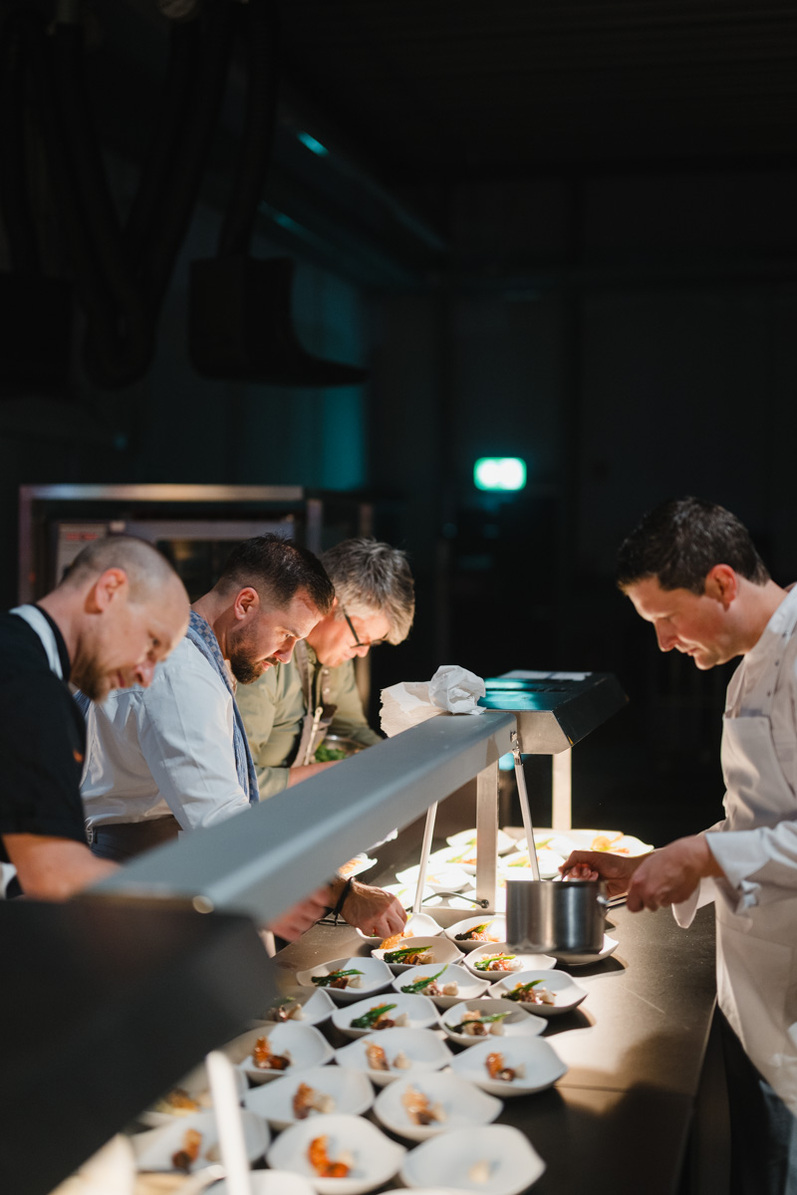 Köche richten Speisen an.