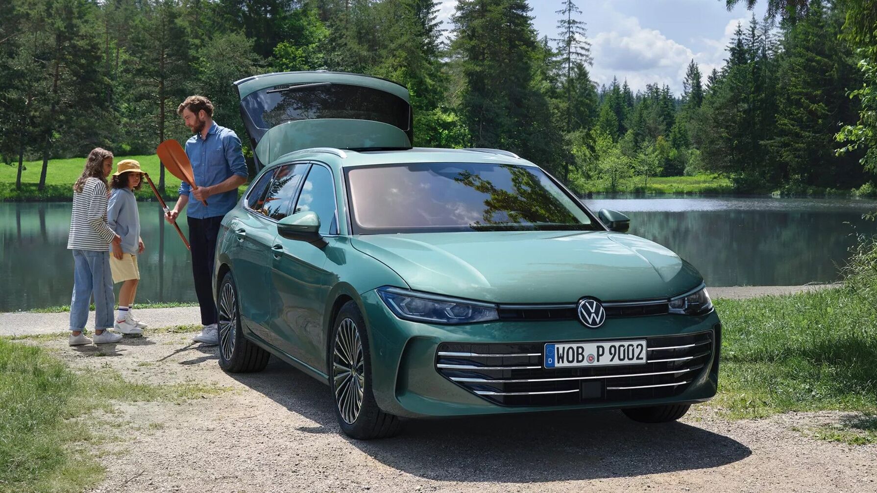 Der VW Passat Variant steht mit geöffneter Heckklappe am Seeufer. Das geräumige Auto bietet viel Platz für Gepäck und Freizeit.