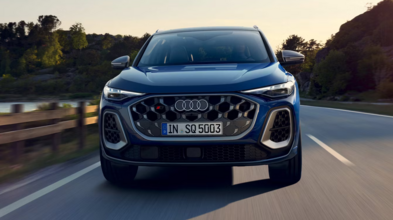 Audi SQ5 in Utranablau Metallic fährt frontal auf der Landstraße, mit Singleframe-Grill in Aluminiumoptik, Matrix LED Scheinwerfern und 21-Zoll-Sportfelgen.