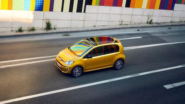 VW e-up! in Gelb während der Fahrt