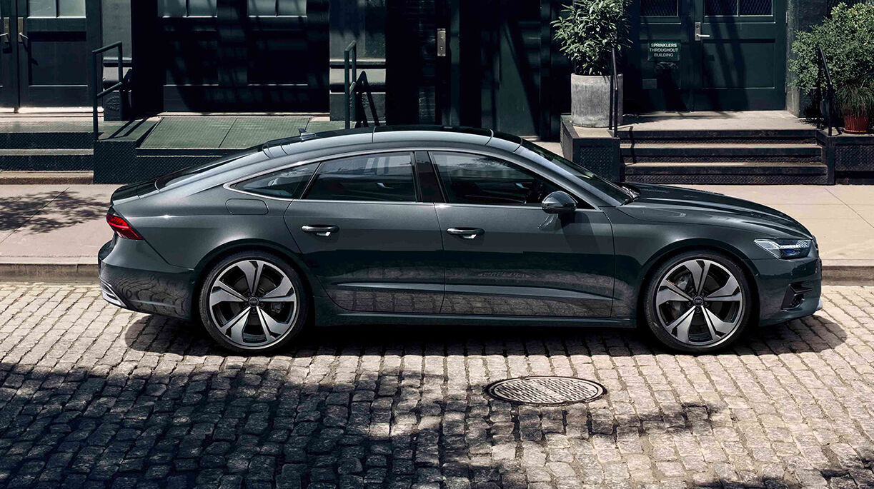 Der Audi A7 in dunkler Lackierung beeindruckt mit seiner coupéartigen Form, breiten Heckpartie, markanter Lichtsignatur und großen, sportlichen Rädern.