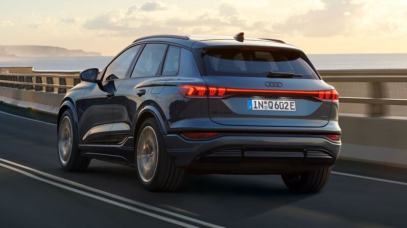 Audi Q6 e-ton fährt dynamisch die Straße entlang.