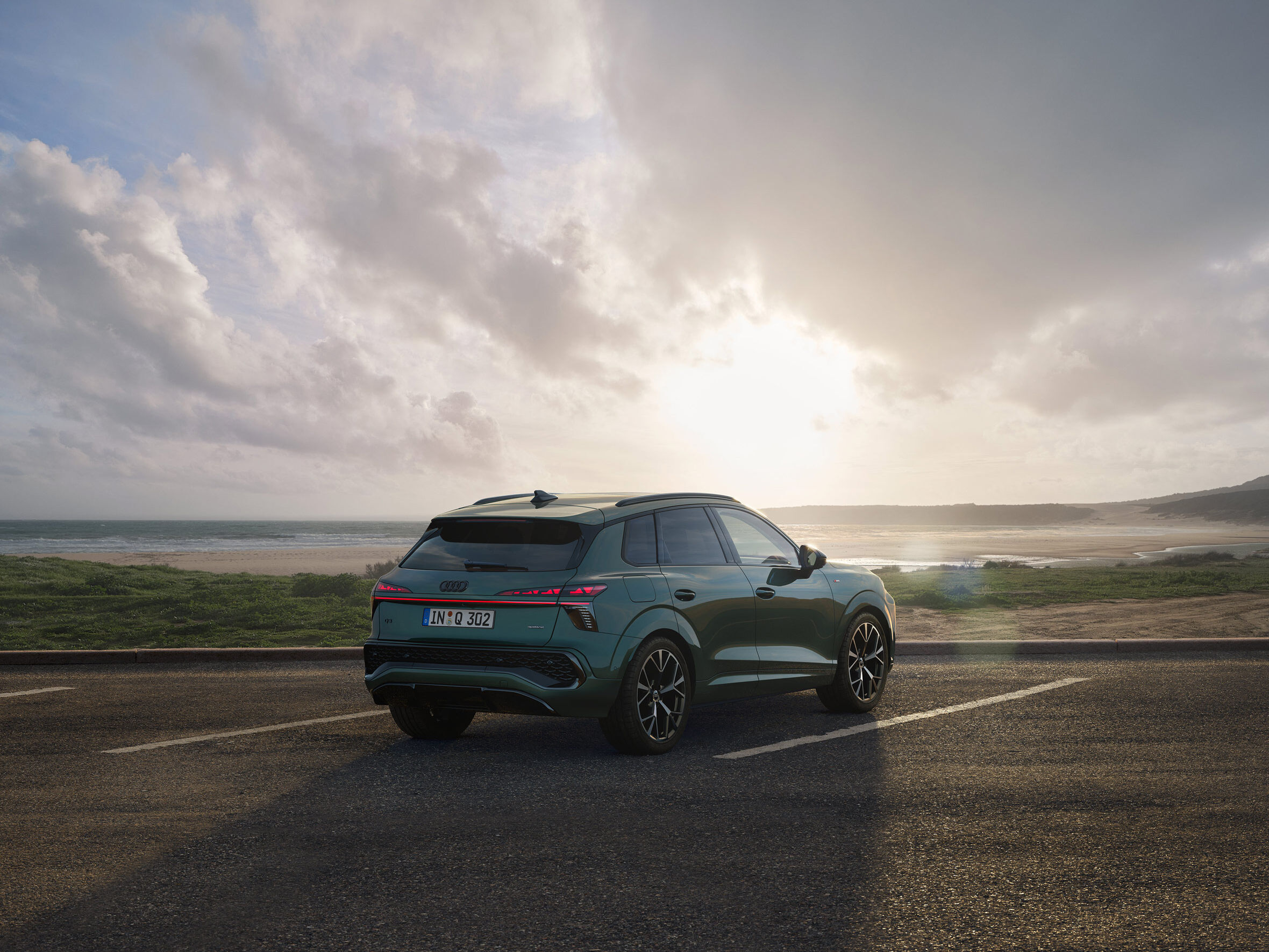 Der neue Audi Q3 auf einem Parkplatz am Strand bei Sonnenuntergang