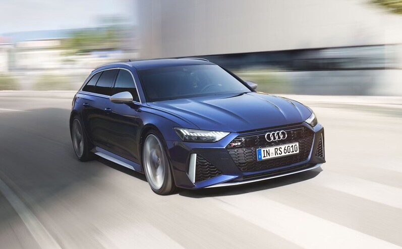 Audi RS6 Avant in Blau, fährt dynamisch die Straße entlang.