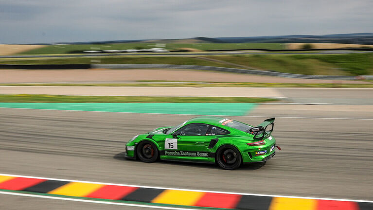 Porsche 911 GT3 RS in grün in voller Fahrt auf der Rennstrecke