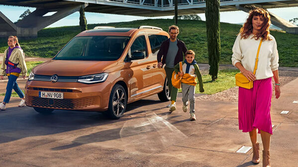 Volkswagen Caddy Life in Orange mit Familie