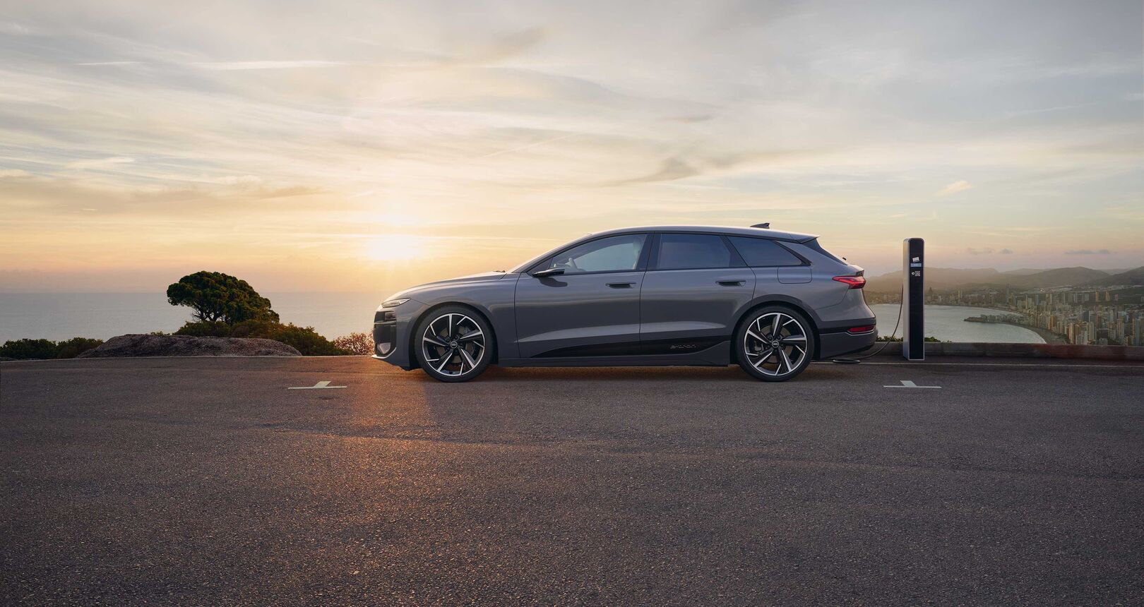 Audi A6 Avant e-tron performance bei Sonnenuntergang an einer Ladesäule